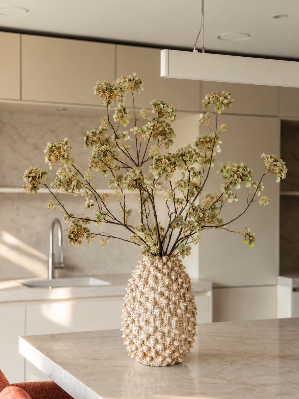 Zijden bloemen boeket Bobbie met groene kunst hortensia's in een lichte vaas op een marmeren kookeiland in een Japandi keuken.