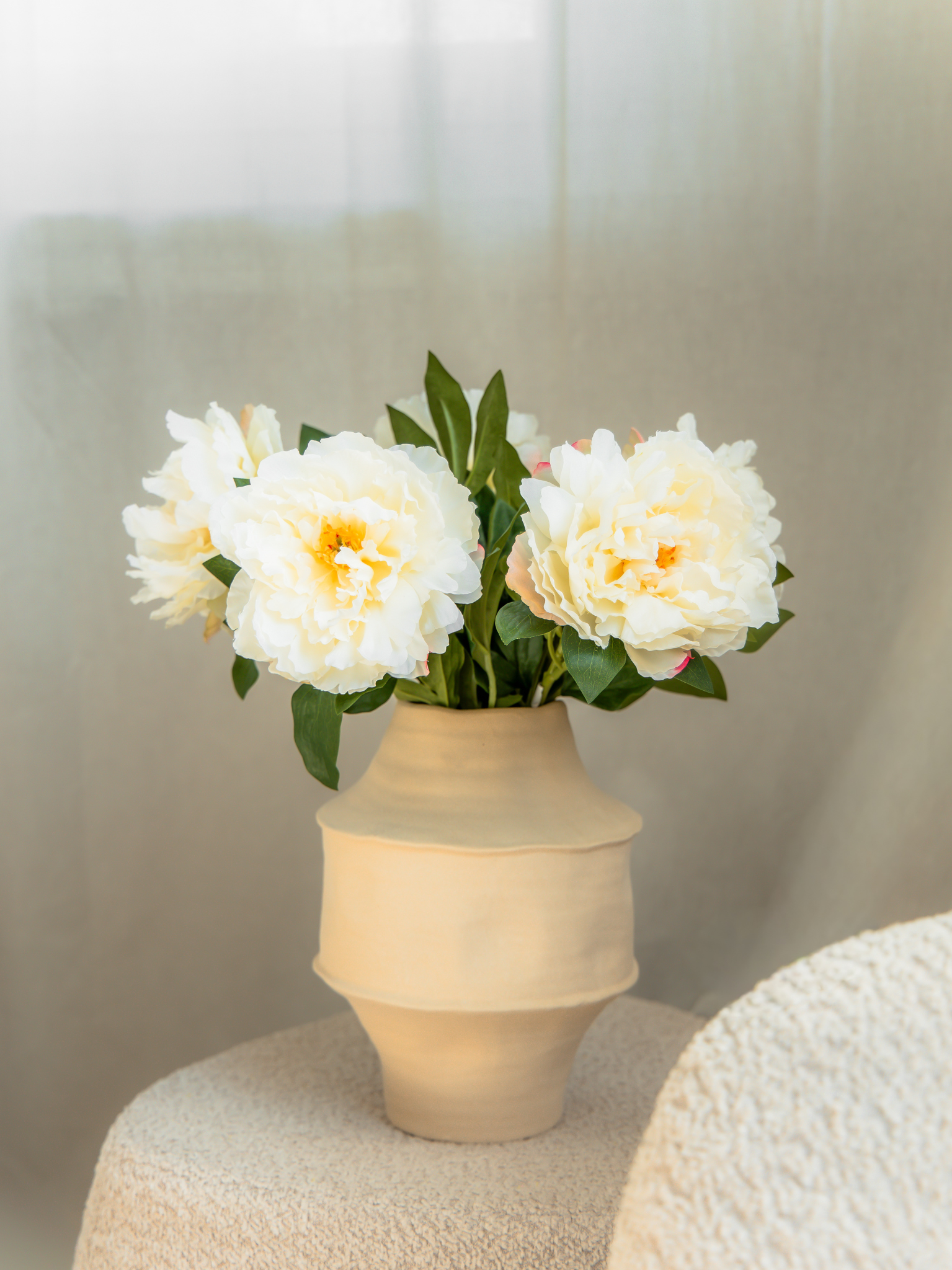 5 witte zijden pioenrozen in beige vaas in interieur
