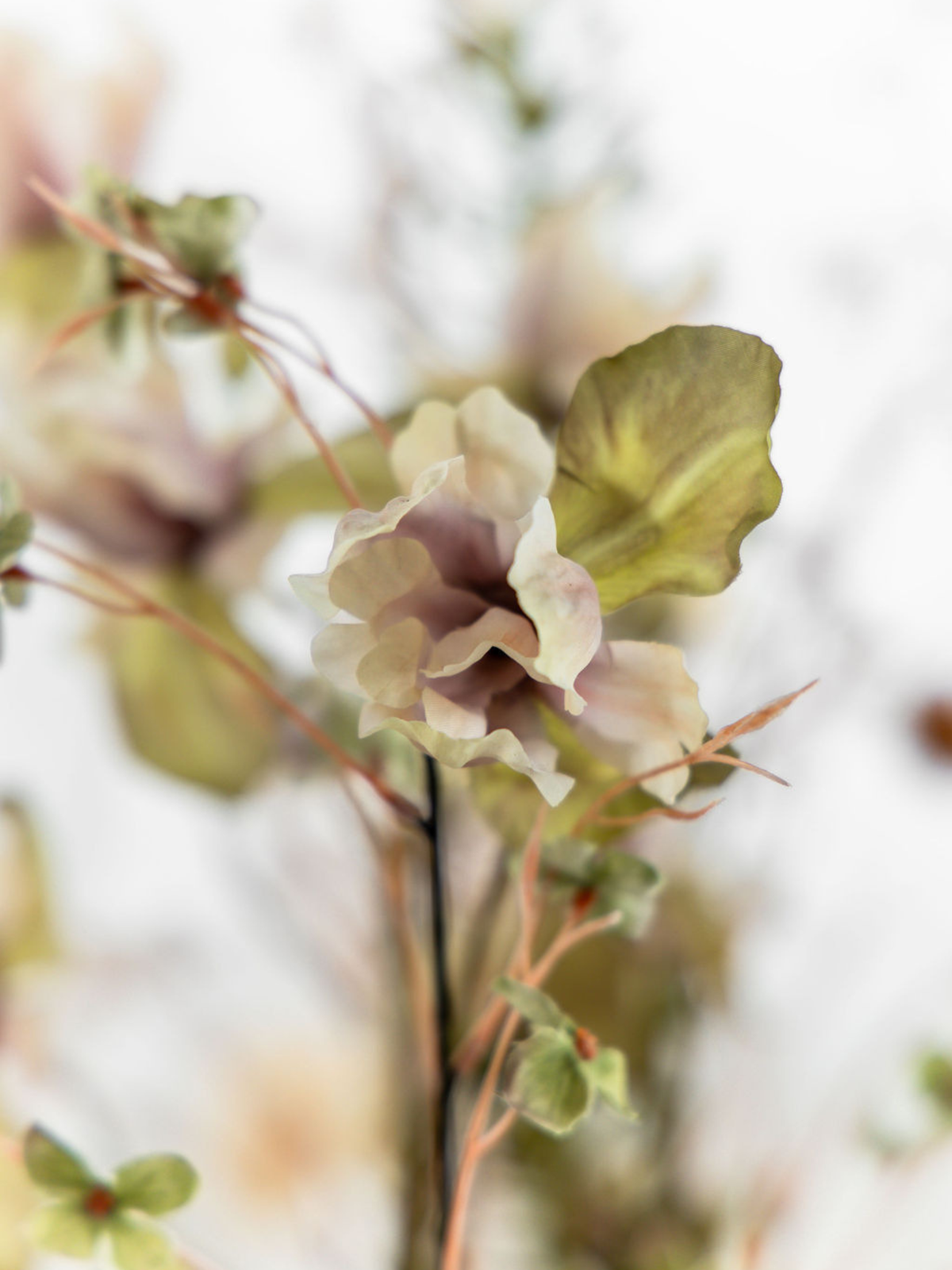 Detail van een groen-crèmekleurige kunstbloem met realistische bloemblaadjes in het natuurlijke zijden herfstboeket Suus.